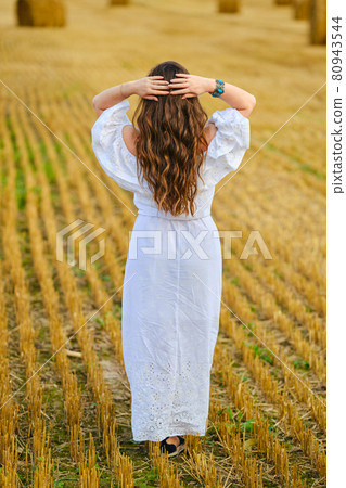 Back view of pretty young woman holding hands behind her head Back view of pretty young woman holding hands behind her head 80943544