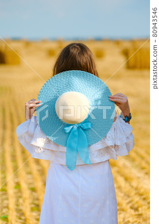 Back view of dreamy young woman walking along the field Back view of dreamy young woman walking along the field 80943546