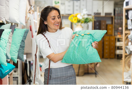 Woman choosing pillow at household goods store 80944136