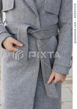 gray woolen coat closeup detail with model hands on city street background gray woolen coat closeup detail with model hands on city street background 80944329