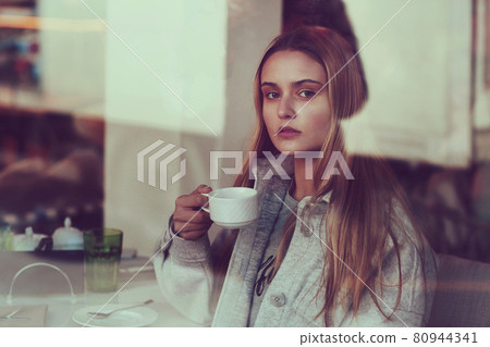 blond long hair beautiful girl with cup of coffee close up portrait blond long hair beautiful girl with cup of coffee close up portrait 80944341