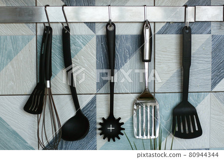 kitchen close up fragment with spatulas , mixer utensils on blue tile background kitchen close up fragment with spatulas , mixer utensils on blue tile background 80944344