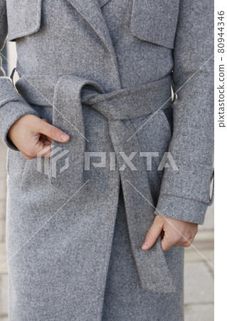 gray woolen coat closeup detail with model hands on city street background gray woolen coat closeup detail with model hands on city street background 80944346