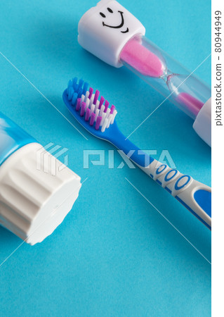 Blue background with a toothbrush and hourglass, kids brushing time Blue background with a toothbrush and hourglass, kids brushing time 80944949