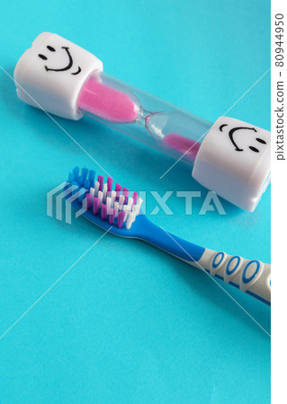 Blue background with a toothbrush and hourglass, kids brushing time Blue background with a toothbrush and hourglass, kids brushing time 80944950