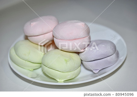 Colorful delicious marshmallows on a white plate Colorful delicious marshmallows on a white plate 80945096