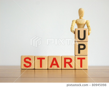 Concept word start up on cubes on a beautiful wooden table. Wooden human model. Concept word start up on cubes on a beautiful wooden table. Wooden human model. 80945098