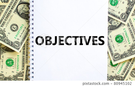 Objectives symbol. The concept word 'Objectives' on white note. Beautiful background from dollar bills. Business and objectives concept. Objectives symbol. The concept word 'Objectives' on white note. Beautiful background from dollar bills. Business and objectives concept. 80945102