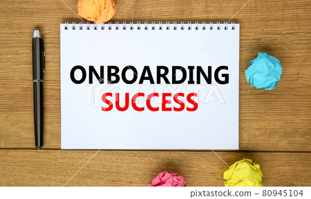 Onboarding success symbol. Words 'Onboarding success' on white note on beautiful wooden table, colored paper, black metallic pen. Business, onboarding success concept. Copy space. Onboarding success symbol. Words 'Onboarding success' on white note on beautiful wooden table, colored paper, black metallic pen. Business, onboarding success concept. Copy space. 80945104