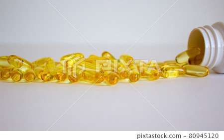 White vial with yellow vitamins tablets, fish oil, Omega Vitamin E. Pills on a white background. Web banner with a copy space. 80945120