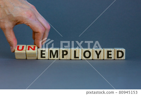 Hand turns a cube and changes the word 'unemployed' to 'employed'. Beautiful grey background, copy space. Business concept. Hand turns a cube and changes the word 'unemployed' to 'employed'. Beautiful grey background, copy space. Business concept. 80945153