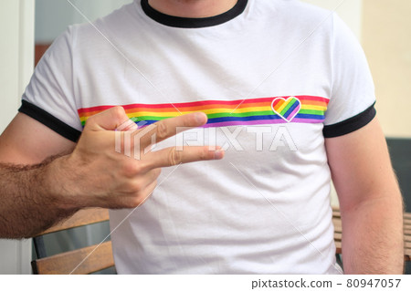 Man in the T shirt with LGBT flag shows sign peace. Gay and lesbian rights concept.  80947057