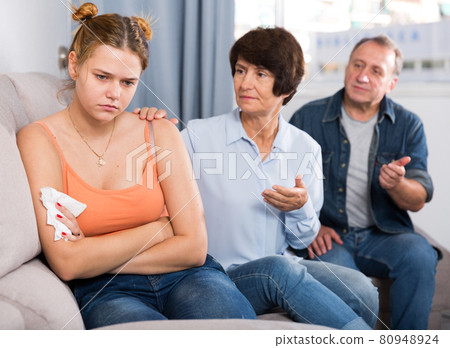 Mom and dad are supporting a sad daughter on sofa Mom and dad are supporting a sad daughter on sofa 80948924