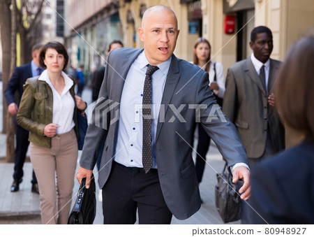 Hurrying businessman running on city street 80948927