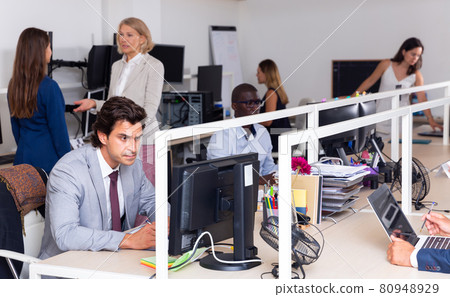 Confused male worker among working colleagues 80948929