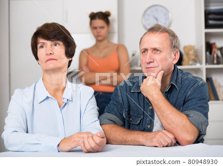 Adult couple is upseting and their daughter is sympathying with them Adult couple is upseting and their daughter is sympathying with them 80948930