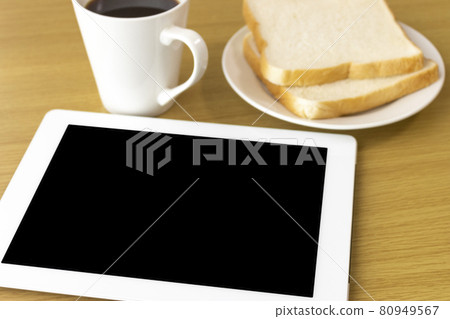 Image of using a tablet device while eating breakfast Image of using a tablet device while eating breakfast 80949567