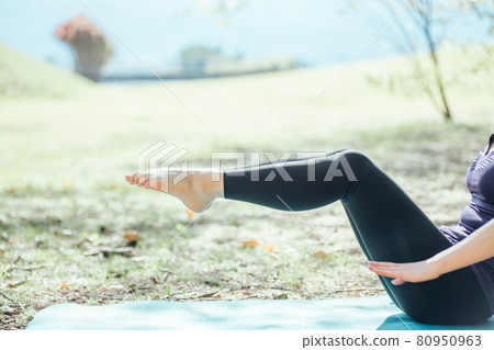 Woman doing yoga outdoors (boat pose) Woman doing yoga outdoors (boat pose) 80950963