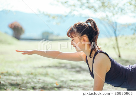 Woman doing yoga outdoors (tiger pose) Woman doing yoga outdoors (tiger pose) 80950965