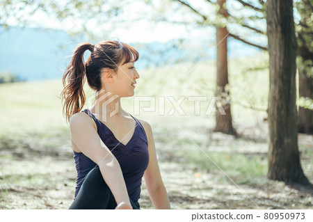 Woman doing yoga outdoors (sitting) Woman doing yoga outdoors (sitting) 80950973
