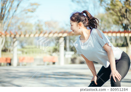 一個女人在公園裡做準備運動（彎曲和伸展） 80951284