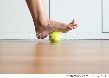 Woman massage with tennis ball to her foot in bedroom,Feet soles massage for plantar fasciitis 80951401
