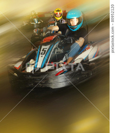 Man and women competing on racing cars Man and women competing on racing cars 80952120