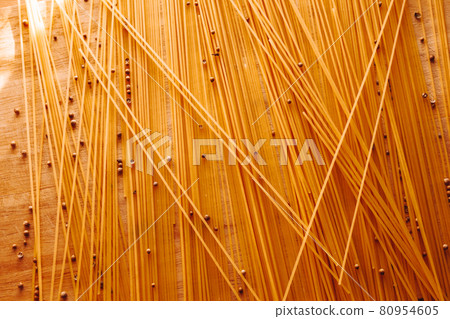 Yellow Spaghetti scattered on the table with black pepper peas. Italian food concept. High quality photo 80954605