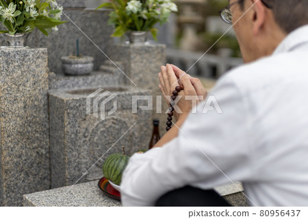 A man visiting a grave and holding hands A man visiting a grave and holding hands 80956437