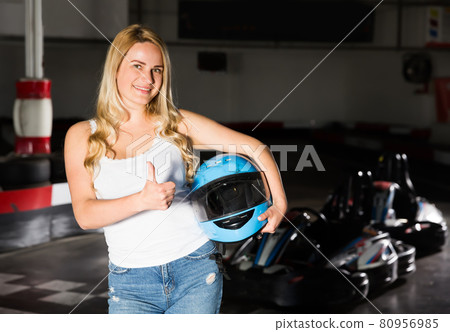Woman with helmet standing near cars Woman with helmet standing near cars 80956985