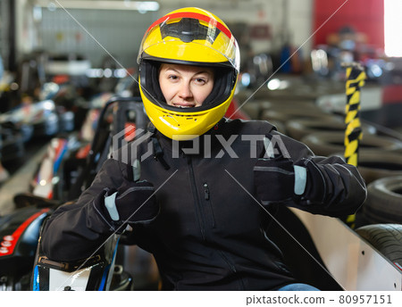 Jolly woman in helmet standing near sport cars Jolly woman in helmet standing near sport cars 80957151