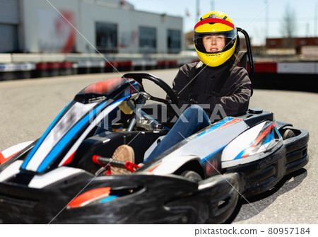 Female go-cart racer at kart circuit outdoors Female go-cart racer at kart circuit outdoors 80957184