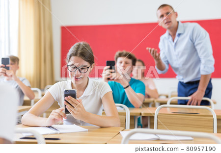 Students using smartphones in university class closeup Students using smartphones in university class closeup 80957190