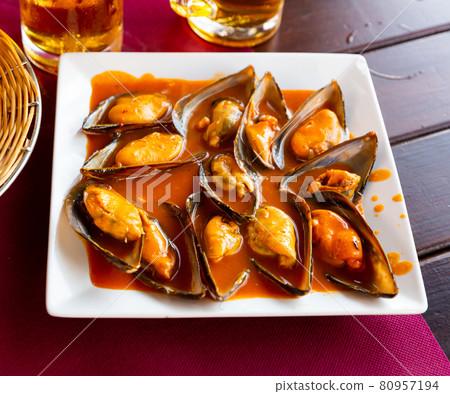 Picture of baked tasty mussels with sauce at plate on table 80957194