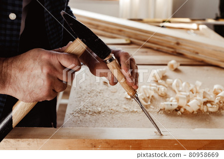 Hands of a carpenter working with chisel and hammer 80958669