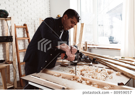 Close up of a carpenter drilling a hole in timber 80959057