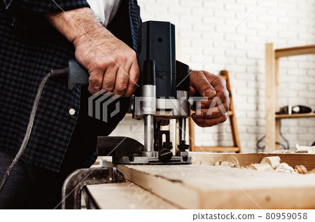 Carpenter cutting wood with electric jigsaw close up 80959058