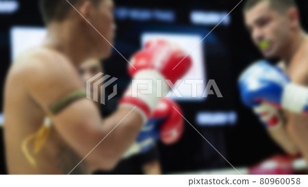 Thai Kick boxing. Blurred images of Muay Thai. Martial Art Kickboxing. Local and foriegn boxer are fighting on the ring at indoor stadium stage. Muaythai is sport competition for traveller sightseeing Thai Kick boxing. Blurred images of Muay Thai. Martial Art Kickboxing. Local and foriegn boxer are fighting on the ring at indoor stadium stage. Muaythai is sport competition for traveller sightseeing 80960058