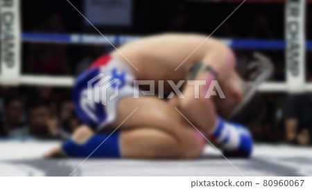 Thai Kick boxing. Blurred images of Muay Thai. Martial Art Kickboxing. Local and foriegn boxer are fighting on the ring at indoor stadium stage. Muaythai is sport competition for traveller sightseeing Thai Kick boxing. Blurred images of Muay Thai. Martial Art Kickboxing. Local and foriegn boxer are fighting on the ring at indoor stadium stage. Muaythai is sport competition for traveller sightseeing 80960067