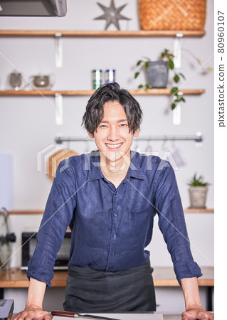 站立在有圍裙的廚房裡的年輕人烹調男孩圖像 站立在有圍裙的廚房裡的年輕人烹調男孩圖像 80960107