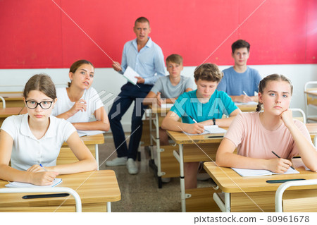 Teenager students sitting at desks Teenager students sitting at desks 80961678