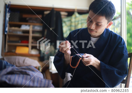 A man sewing 80962285