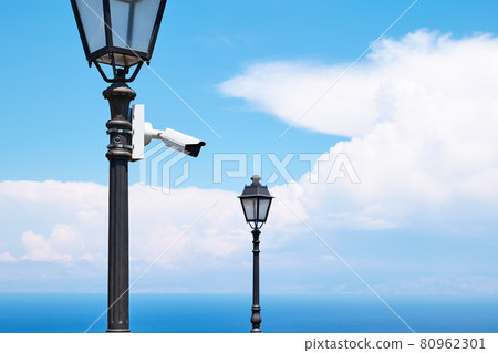 Security camera on a light pole on the street. CCTV surveillance security camera video equipment. Home security system concept. Safety system area control outdoor with copy space, Security camera on a light pole on the street. CCTV surveillance security camera video equipment. Home security system concept. Safety system area control outdoor with copy space, 80962301