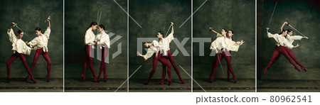 Fight. Two young female ballet dancers like duelists with swords on dark green background. Caucasian models dancing together. 80962541