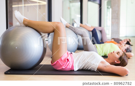 Women doing pilates workout on fitness ball at gym Women doing pilates workout on fitness ball at gym 80962782