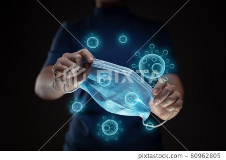 Close up shot of hands holding protective face mask with virus hologram effect. Close up shot of hands holding protective face mask with virus hologram effect. 80962805