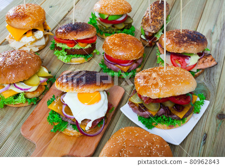 View of assorted appetizing hamburgers on wooden table. 80962843