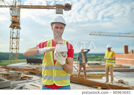 Worker in cotton gloves checking the quality of construction material Worker in cotton gloves checking the quality of construction material 80963691