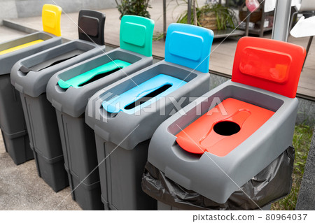Row of many different multicolored plastic waste cans for garbage sorting and recycling at city street outdoors. Environmental protection and nature cotamination danger prevention concept 80964037