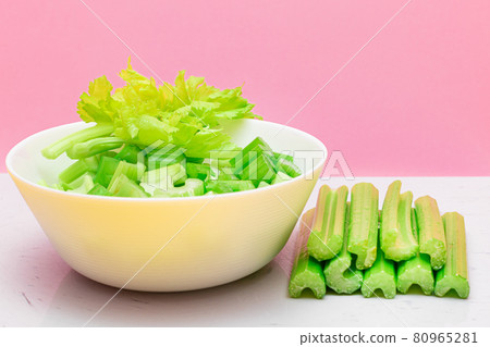 Fresh Chopped Celery Slices in White Bowl with Celery Sticks on White Cutting Board Fresh Chopped Celery Slices in White Bowl with Celery Sticks on White Cutting Board 80965281